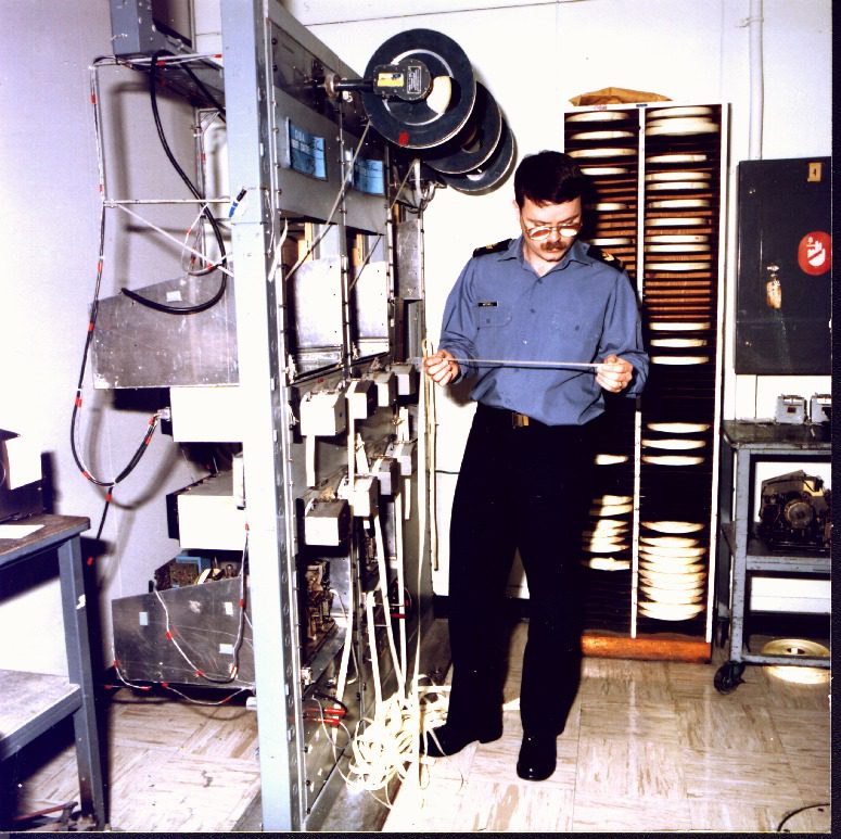 A man working with vintage computer hardware in a lab setting.