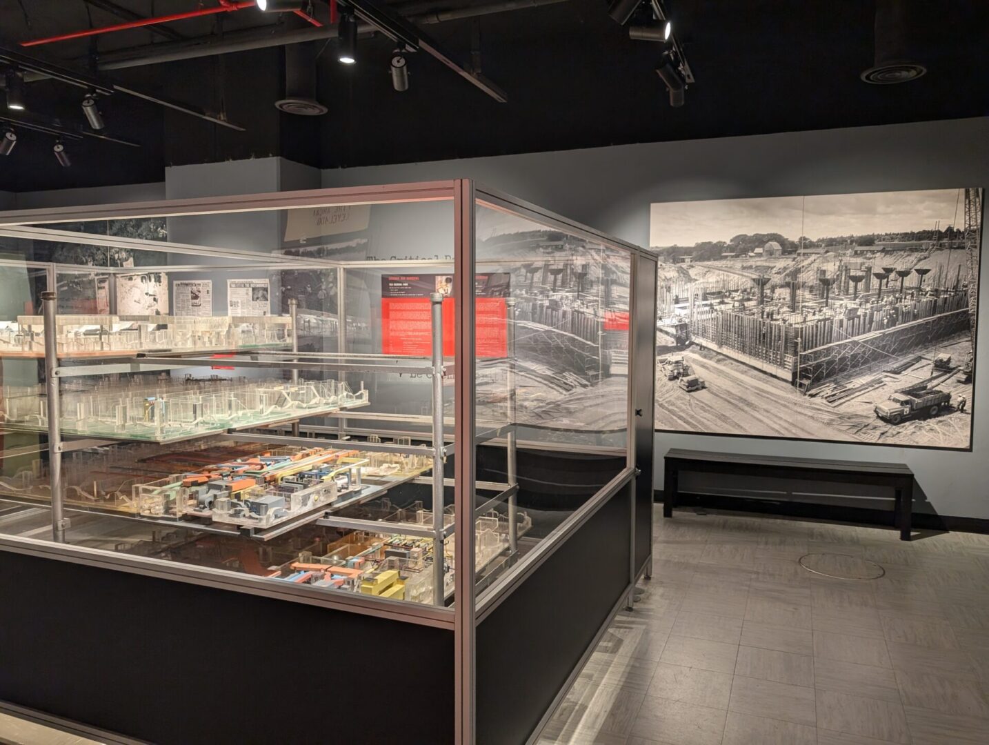 Exhibit of architectural models behind glass in a museum gallery.