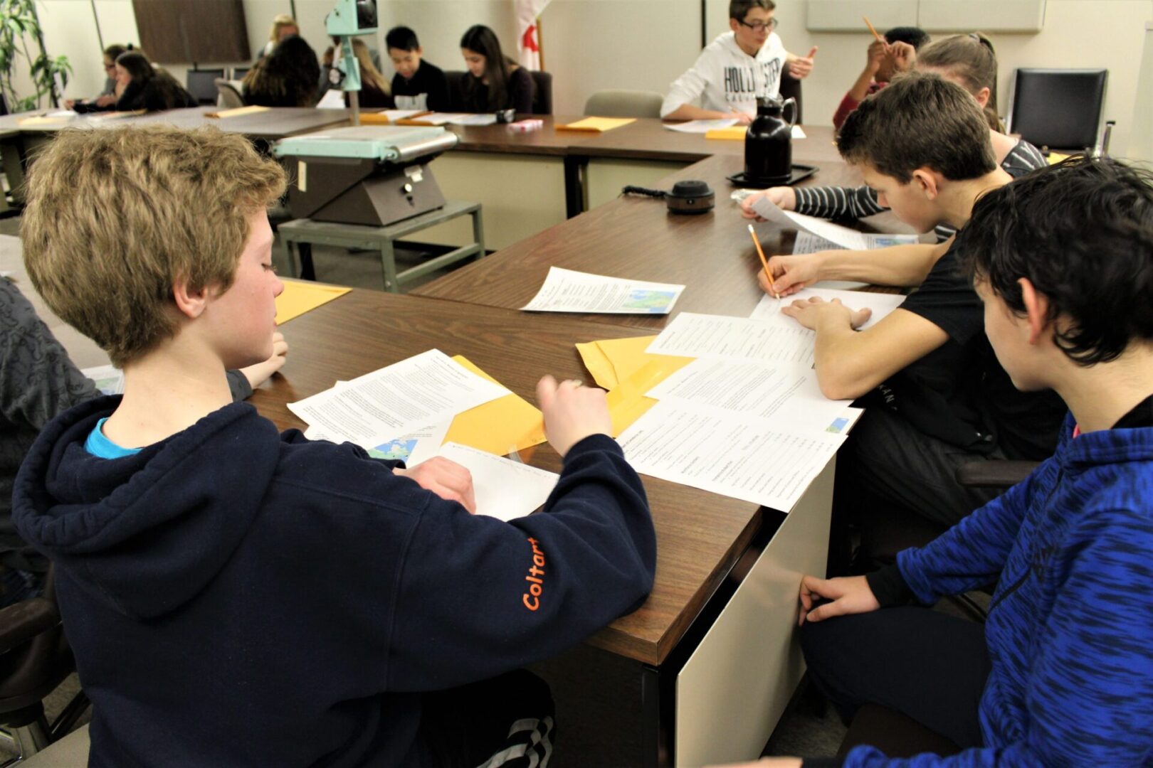 Students collaborating on worksheets in a classroom setting.