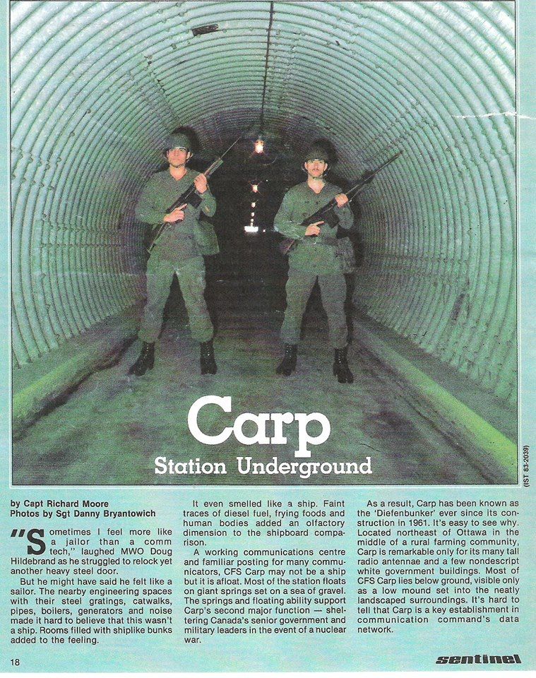 Two soldiers stand inside a large underground tunnel, holding rifles.