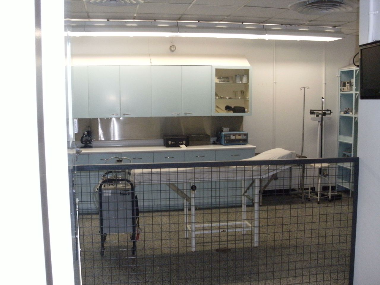 Empty hospital room with medical equipment and bed.
