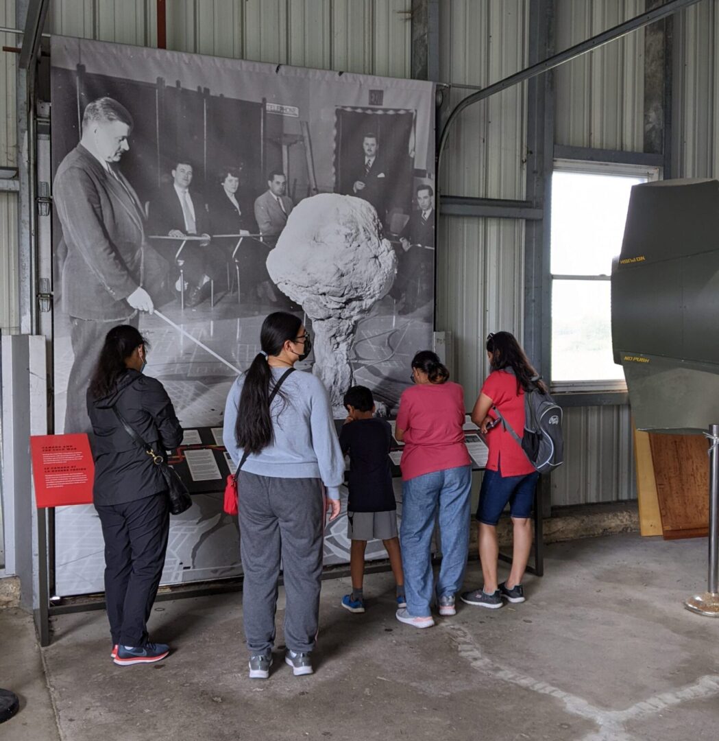 Children observing a historical exhibit with a guide inside a museum.