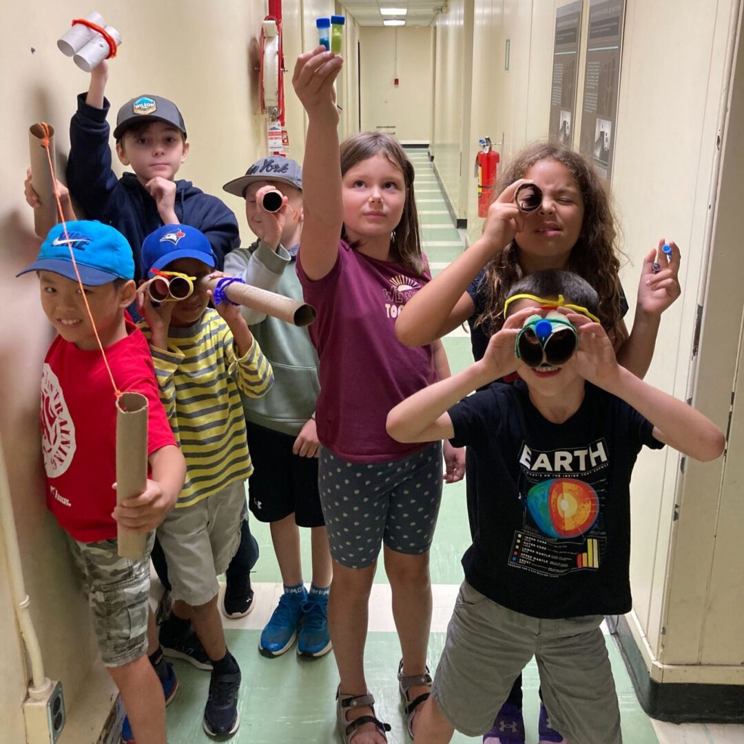 A group of kids playfully posing with toy guns indoors.