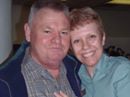 Smiling middle-aged couple posing closely indoors.