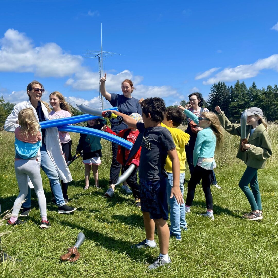 Group of children and adults outdoors with colorful balloons.