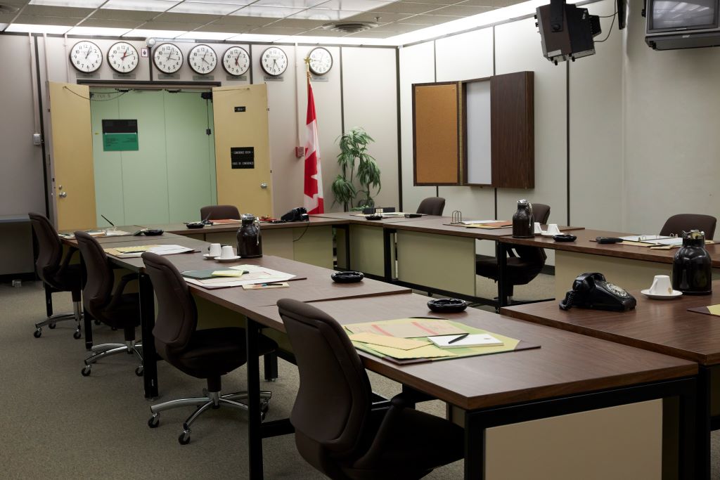 A conference room with tables, chairs, and a whiteboard.