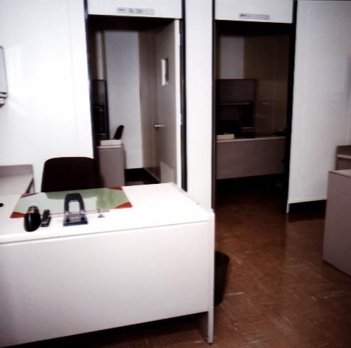 Modern white office desk with computer and chair in a clean workspace.