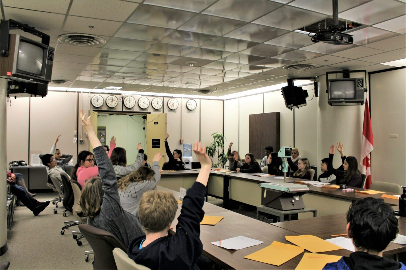 A person raising their hand in a classroom during a meeting or discussion.