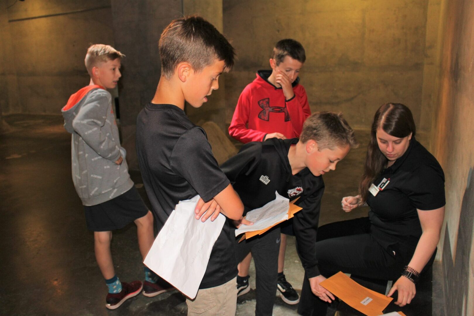 A group of young boys gathered indoors, focused on a task.