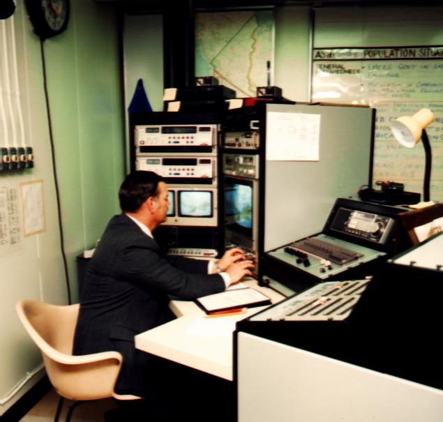 Man working at vintage radio or recording studio equipment.