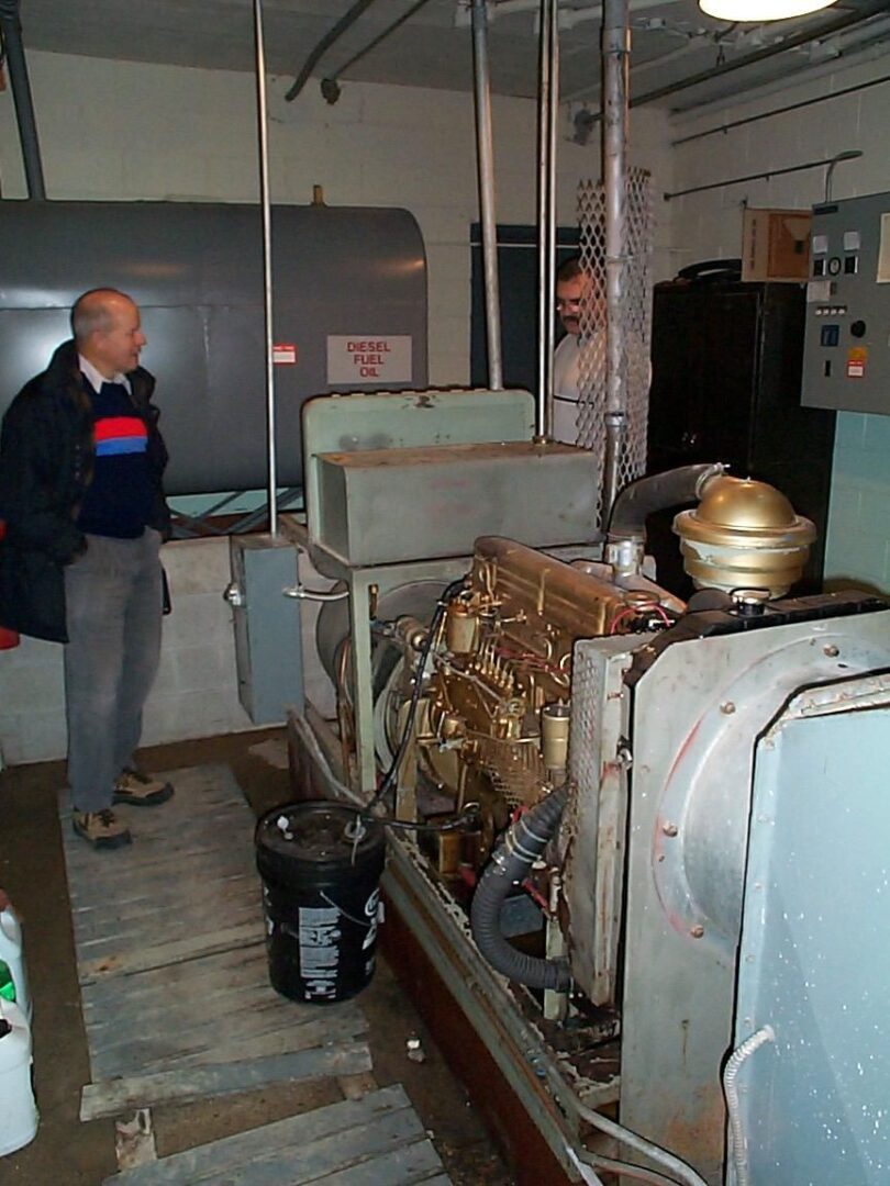 Man observing old industrial machinery in a dimly lit room.