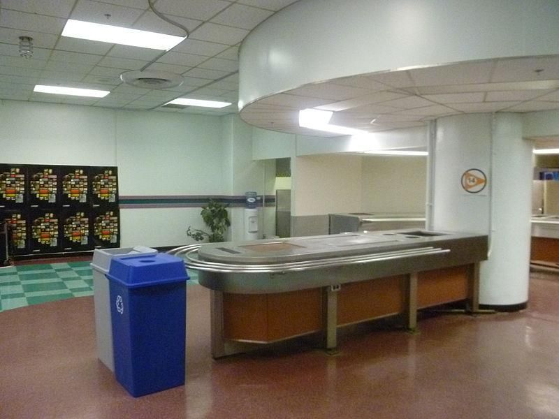Empty cafeteria serving area with a blue recycling bin.