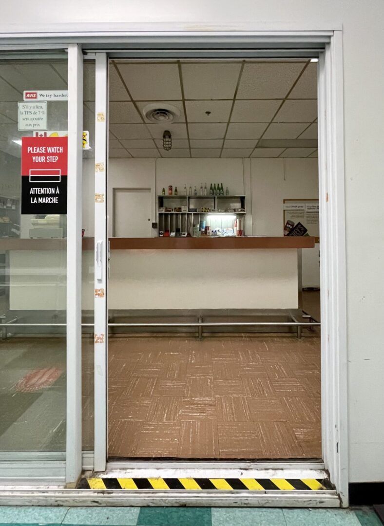 Empty coffee shop interior with counter and plants.