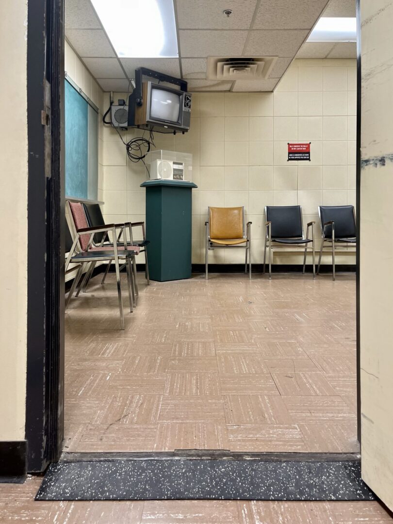 Empty hospital waiting room with chairs and a TV.