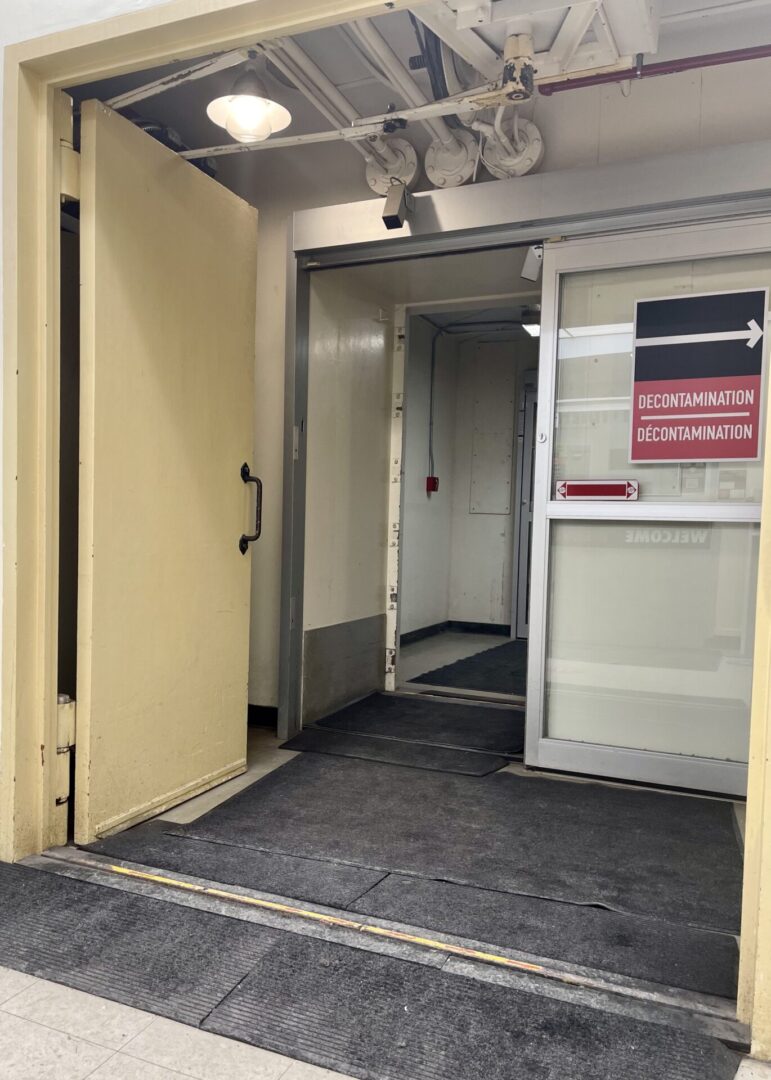 Entrance to a building with an open door and a sign on the wall.