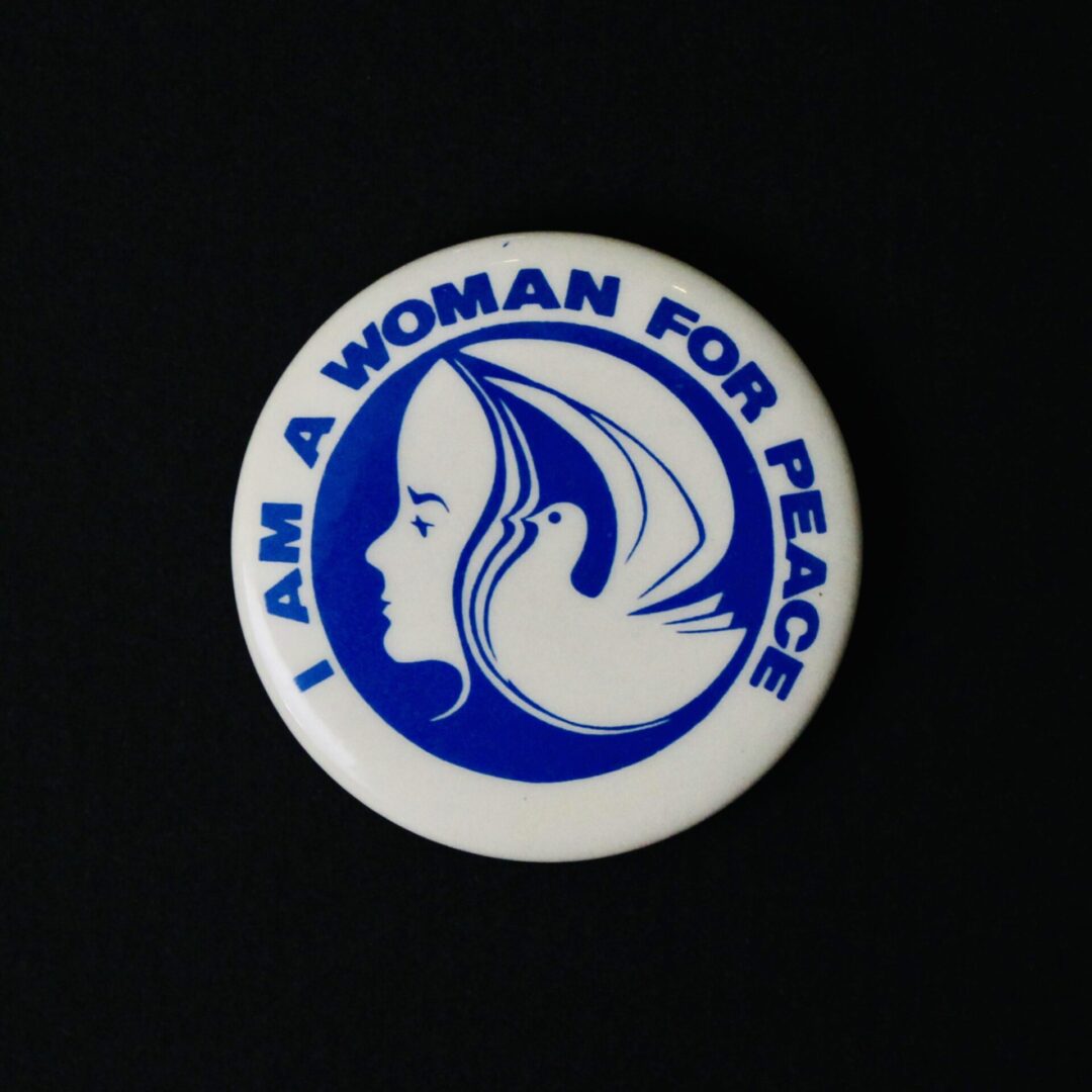 Button pin with a woman’s face and the text 'I am a woman for peace.'