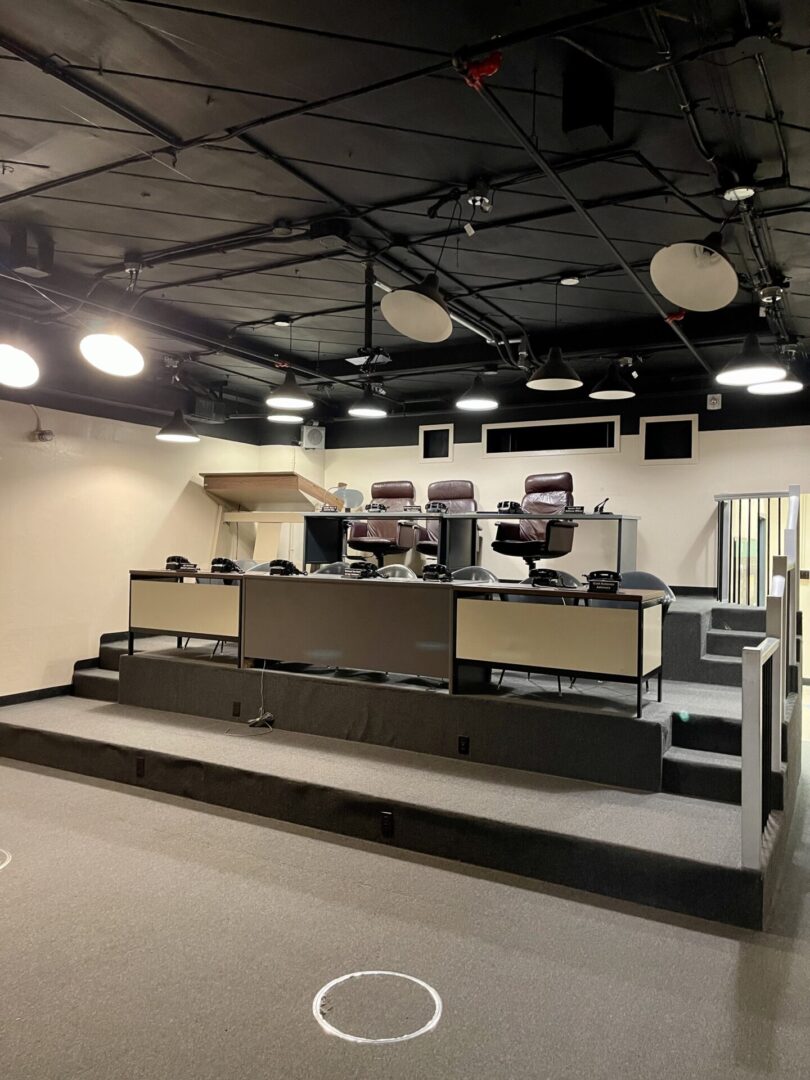 Empty broadcast studio with multiple monitors and cameras.