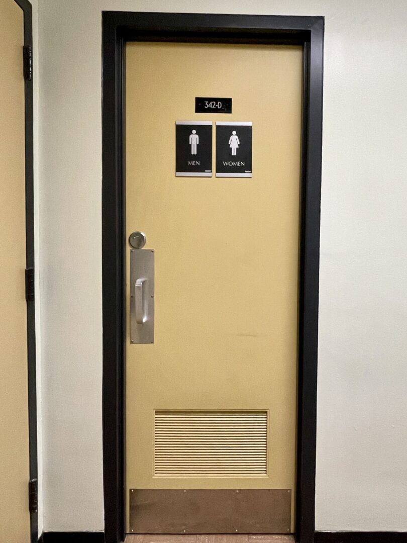 Closed restroom door with male and female signs.