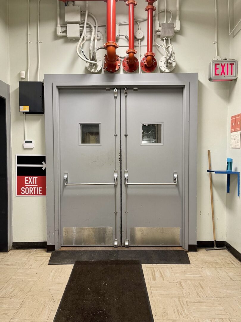Double doors with small windows in a commercial setting.