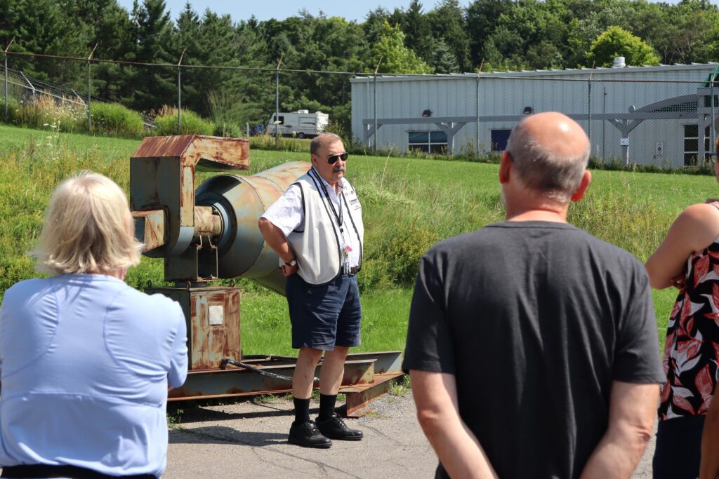 Volunteer guide speaks to a group of visitors in front of the Diefenbunker.