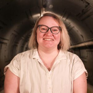 Woman in glasses and white blouse smiling in the Diefenbunker Museum Blast Tunnel